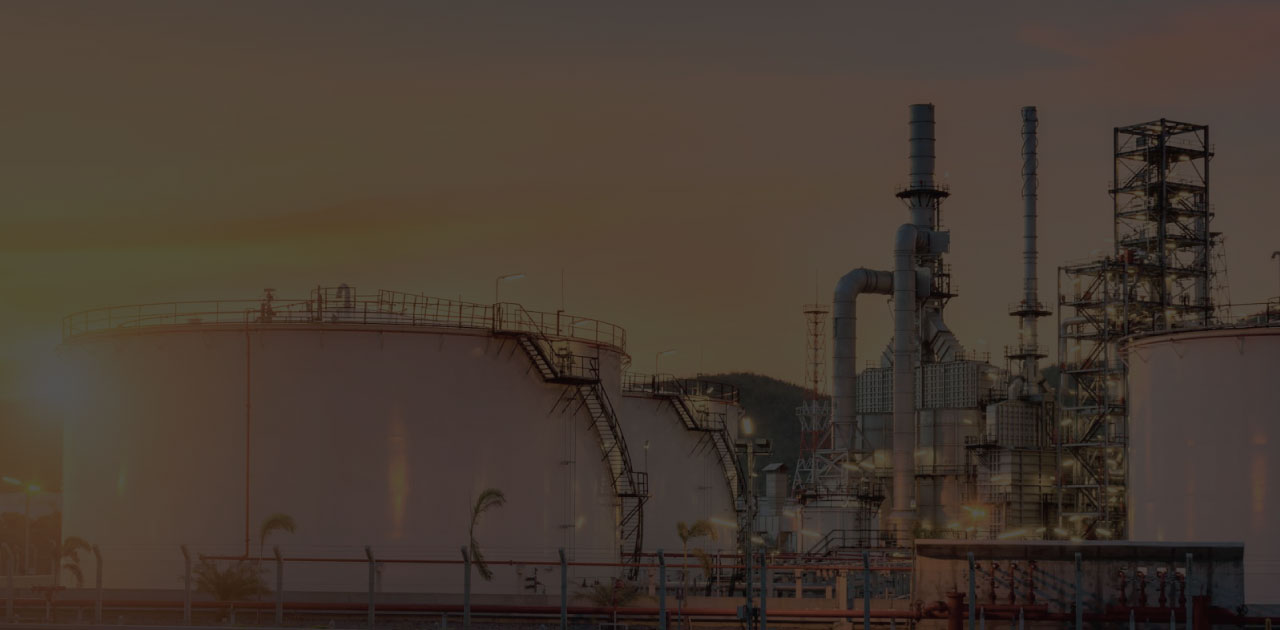 Refinery storage tanks and process units at dusk